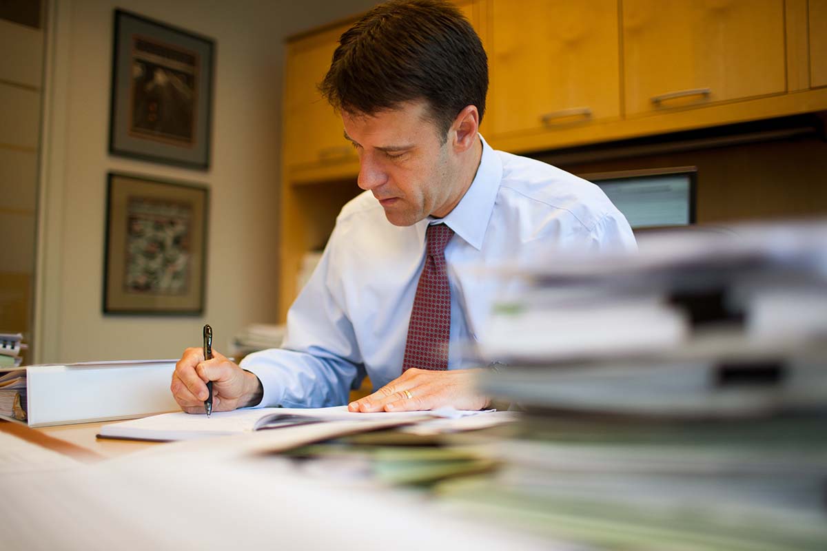 J. Gordon Seymour, signing papers at a desk